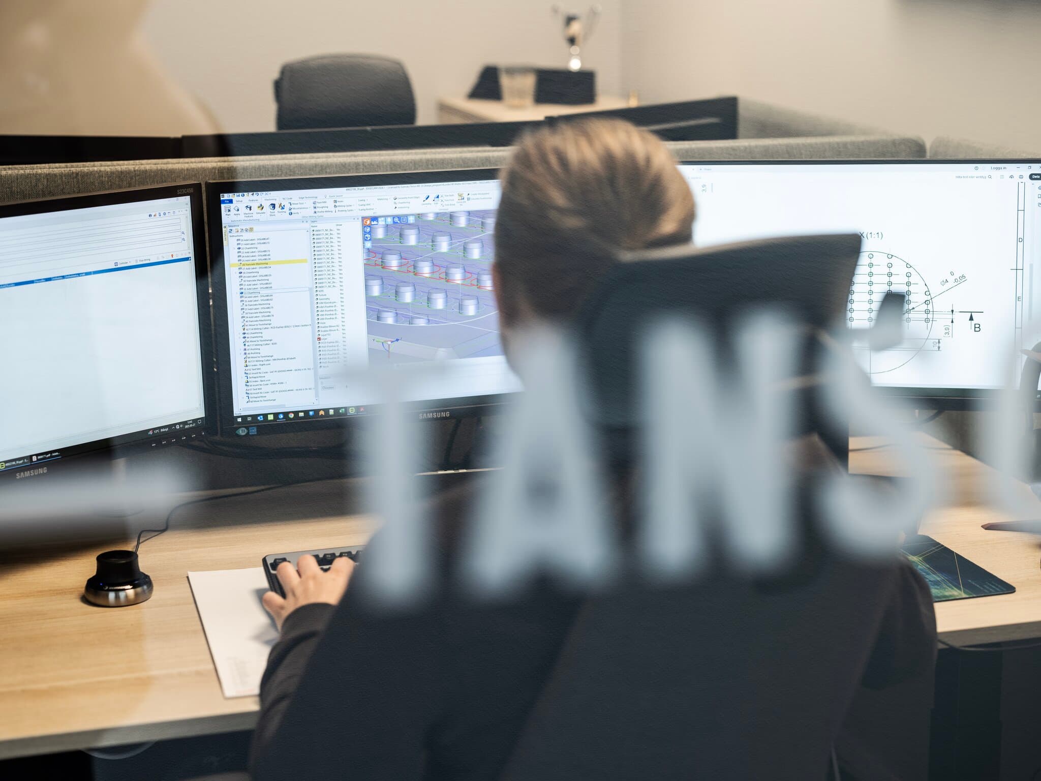 Picture taken from behind of person working with CAD/CAM