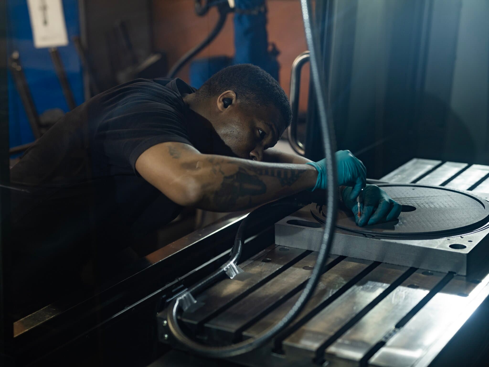 Person bearbetar grafitkomponent i verkstadsmiljö